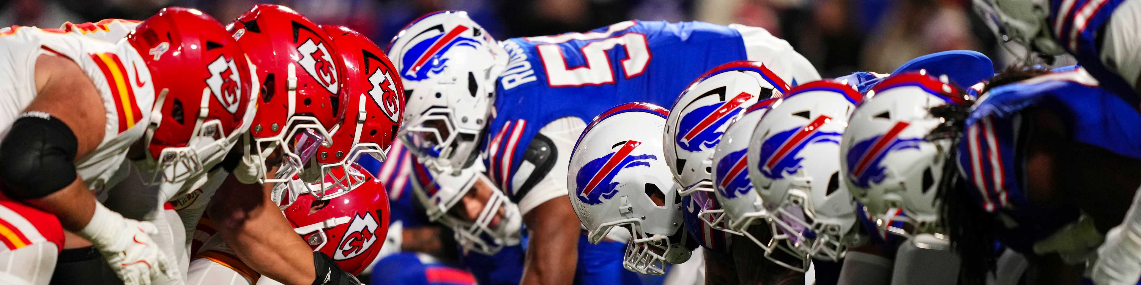 Line of scrimmage: Chiefs in red helmets facing Bills in white and blue helmets, football players ready to snap the ball