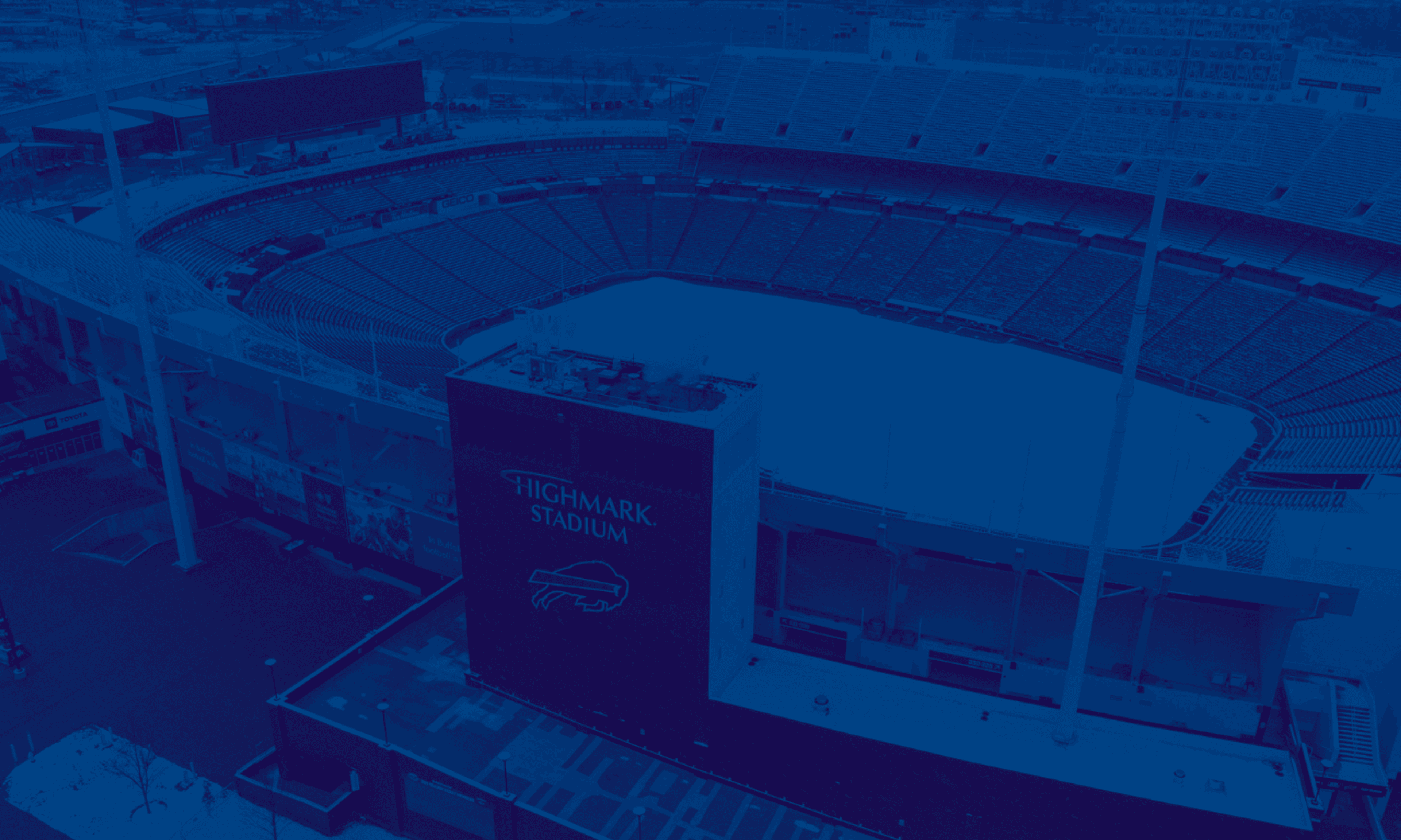 Aerial view of Highmark Stadium, an indoor sports venue with blue tinted overlay, showing the arena's distinctive architecture and surrounding facilities.
