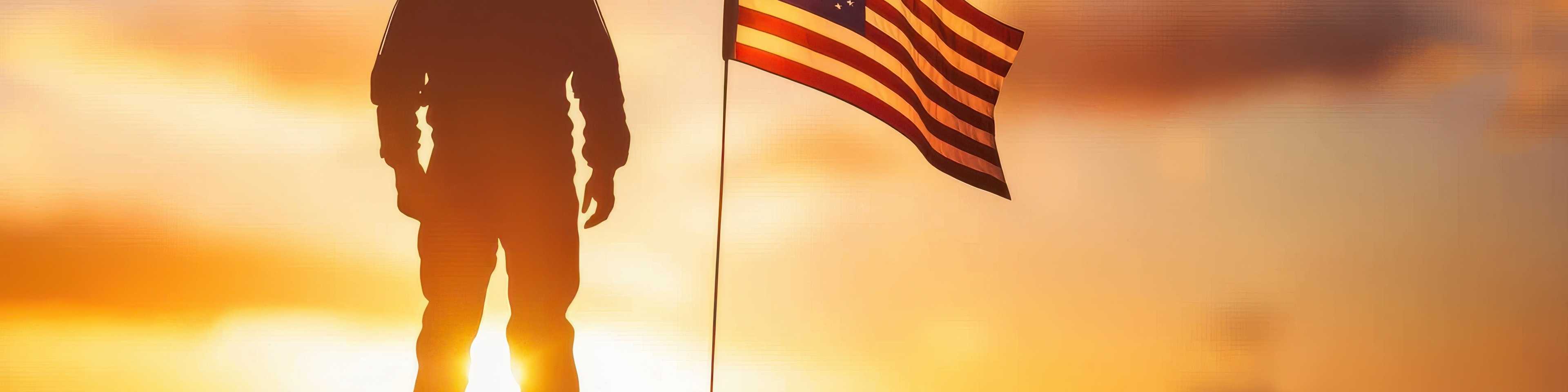 Silhouette of a soldier standing next to an American flag against a golden sunset sky, symbolizing patriotism and military service.