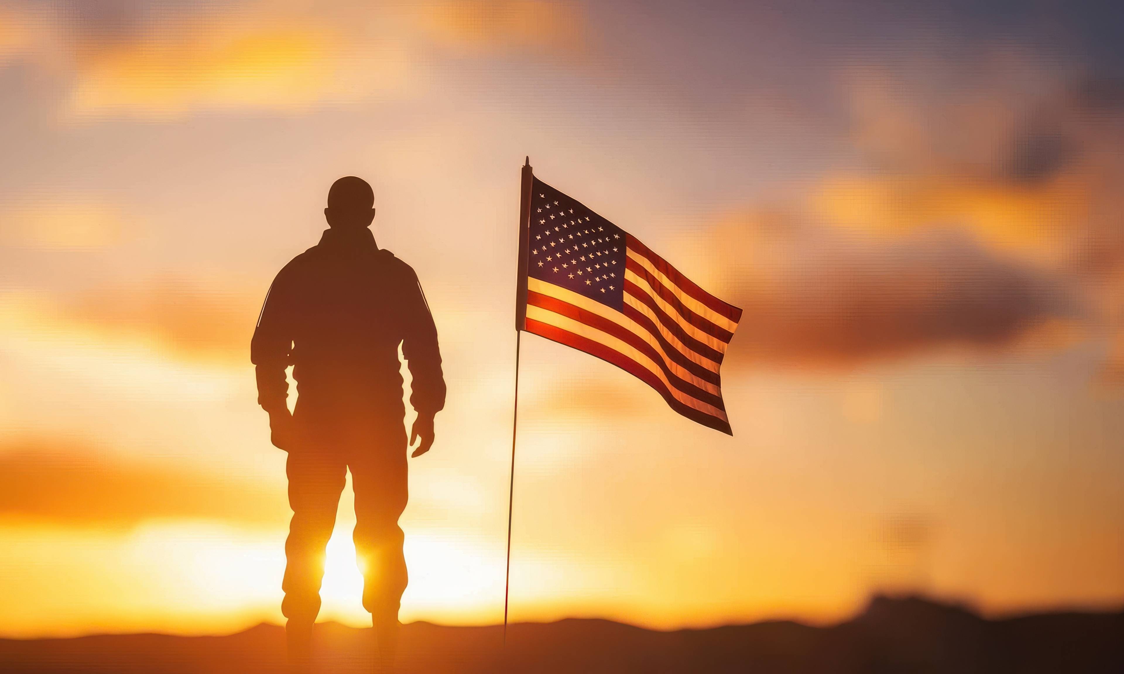 Silhouette of a soldier standing next to an American flag against a golden sunset sky, symbolizing patriotism and military service.