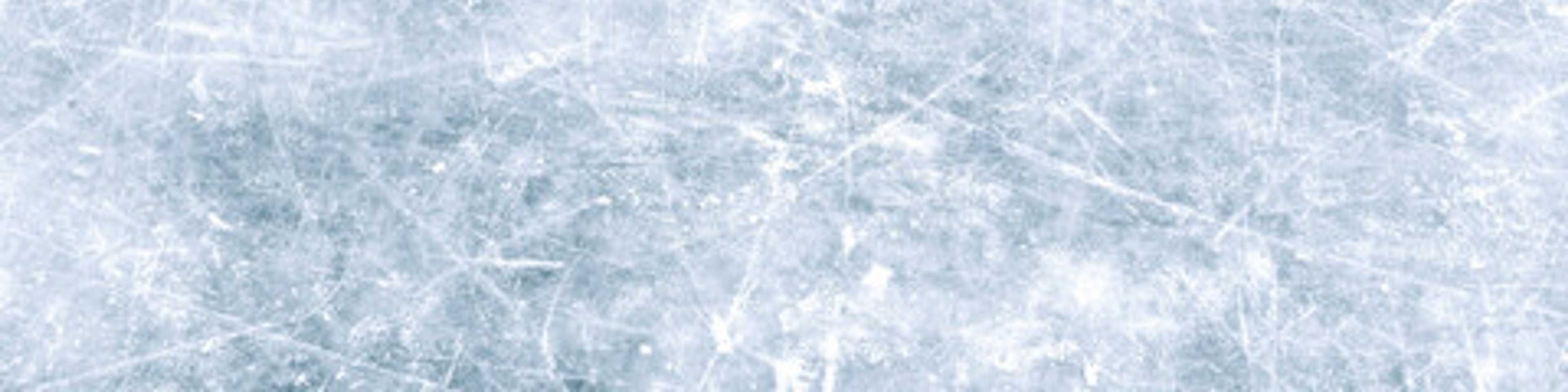Close-up of a textured ice surface with scratches and cracks creating an abstract frozen pattern in shades of white and light blue.