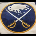 Military emblem patch featuring a buffalo head at top, crossed swords below, and gold handles, set on dark blue background with gold border.